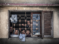 Palestinians seen from the window of the house before an Israeli air raid on a nearby house. Israeli air strikes on the Gaza Strip, killing...