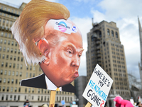 At a Feb. 25, 2017 Affordable Care Act repeal protest rally in Philadelphia, PA, artist Carla Krash holds up a sign with a cartoon image of...
