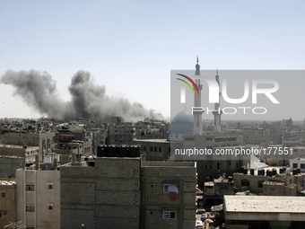 Smoke billows from a building hit by an Israeli air strike in the town of Rafah, in the southern Gaza Strip, on July 14, 2014. The Arab Leag...