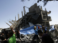 A Palestinians searching a of a destroyed house following an Israeli missile strike, in Rafah in the southern Gaza Strip on July 14, 2014. I...