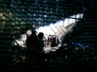 A Palestinians searching a of a destroyed house following an Israeli missile strike, in Rafah in the southern Gaza Strip on July 14, 2014. I...