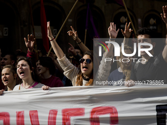 Students gesture and shout behind a banner during a demonstration against University taxes in Barcelona on March 2, 2017.  (