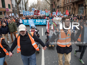 Protesters carry flags through central London during a demonstration in support of the NHS on March 4, 2017 in London, England. Thousands ma...
