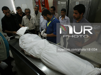 The body of Palestinian man, at the mortuary of a hospital in Rafah in preparation for a funeral service for victims of Israeli bombardment...