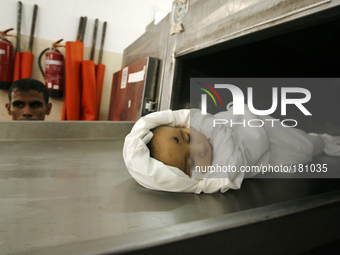 The body of five-month-old Fares al-Mahmum, at the mortuary of a hospital in Rafah in preparation for a funeral service for victims of Israe...