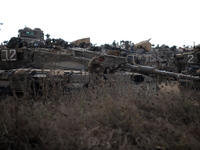UNSPECIFIED, ISRAEL - JULY 19, 2014: An Israeli soldier sits on a tank in an army deployment area near Israel's border with the Gaza Strip,...