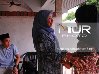 Normah Ismail, centre, embraces her niece, Nur Diyana Yazeera, right, daughter of Malaysia Airlines, flight attendant, Dora Kassim, onboard...