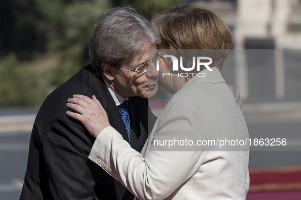 Italian Prime Minister Paolo Gentiloni, left, greets German Chancellor Angela Merkel during arrivals for an EU summit at the Palazzo dei Con...