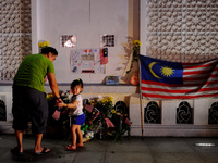 A young child looks at the camera after placing flowers during a special prayer vigil for the ill fated Malaysia Airlines, MH17 in Kuala Lum...