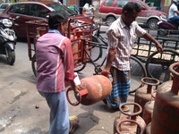 A Customer carrying Liquid Petroleum Gas (LPG) cylinders at Central Kolkata in India ,Subsidised LPG cylinder price hiked by Rs5.57, ATF cut...