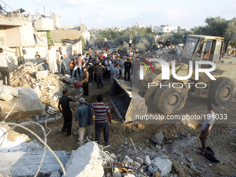Removes rescue workers search for bodies of the family-Najjar, from under the rubble of their home following an Israeli air strike on Khan Y...