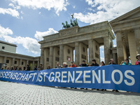 Paople attending the 'March for Science' hold a banner reading 'science is without borders' in front of the Brandenburg Gate in Berlin, Germ...