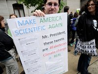 Protestor holds up a sign opposing conservative standpoints of the Trump-Administration regarding science and the environment. Thousands par...
