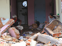  Sri Lankan garbage collapse survivors sit and discuss among the debris of their   damaged house in Meetotamulla, on the outskirts of Colomb...