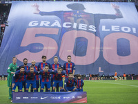 Barcelona's team poses as a banner is unfurled in tribute to Argentinian forward Lionel Messi for his 500th goal for the club before the Spa...