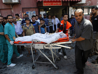 Physician assistants are moving the body at Nasser hospital a after an Israeli air strike in Khan Yunis, in the southern Gaza Strip on July...
