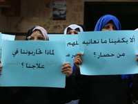 Palestinian women hold placards during a protest demanding end an Israeli blockade of the Gaza Strip, at Al-Shifa hospital in Gaza City on A...