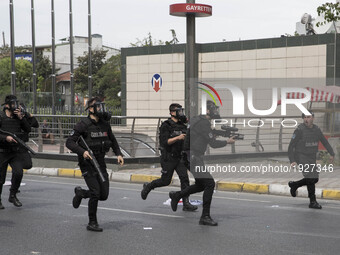Police are seen running past makeshift barricades as they chase protesters through the streets during a May Day demonstration on May 1, 2017...