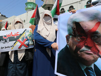  Palestinian woman hold signs as supporters of Hamas, Jihad Islamic and Al Ahrar movement gather to protest against President of the State o...