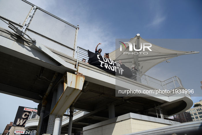 Protesters carry a banner that reads DUMP TRUMP, as they cross the pedestrian bridge that leads towards the USS Intrepid, in New York City,...