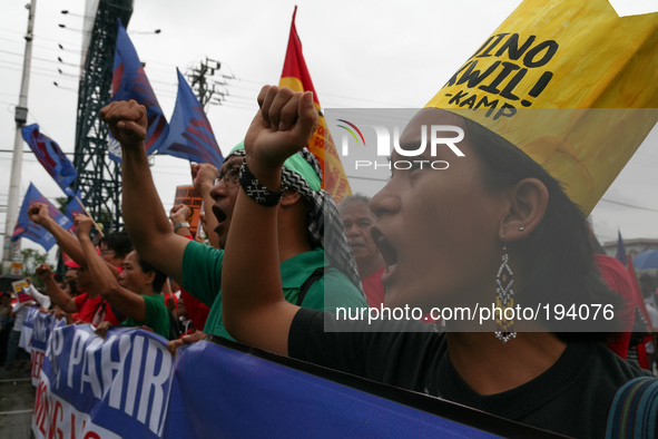 Protesters shout in anger as they march along Commonwealth Avenue in Quezon City. Thousands of protesters rallied at the same time as Presid...
