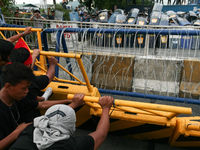 Protesters trying to pull down concrete barriers along Commonwealth Avenue in Quezon City as the police readies in formation. Thousands of p...