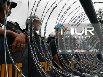 Crowd control police on stand-by behind concertina razor wires along Commonwealth Avenue in Quezon City. Thousands of protesters rallied at...