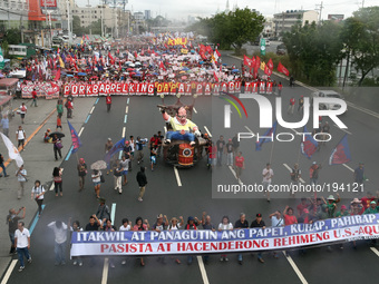 Protesters in the thousands march along Commonwealth Avenue in Quezon City. Thousands of protesters rallied at the same time as President Aq...