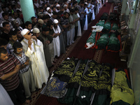 A Palestinian mourners pray around the bodies of fifteen members of the Abu zeid, Duheir and al-Hashash families, that were killed in an Isr...