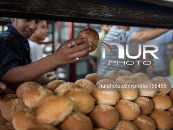 2-	A Palestinian man shows a piece of recently made bread while making line to buy as much bread as he can fearing future shortages in the G...