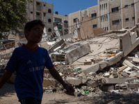 A Palestinian boy walking in front of one of the many buildings destroyed by the Israeli airstrikes at the Shati district in Gaza.  (