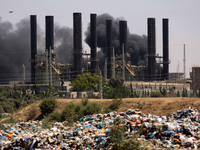  	Smoke and flames rise from the Gaza power plant after it was hit by Israeli strikes, in the Nusseirat Refugee Camp, central Gaza Strip, Tu...