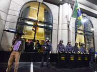 Police officers stand guard during a people protest against the president of Brasil, Michael Temer, at the Paulista avenue, at Sao Paulo, Br...