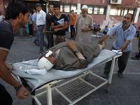 A Palestinian man, who was wounded in an Israeli strike, arrives at a hospital in Khan Yunis in the southern Gaza Strip on July 30, 2014. Is...