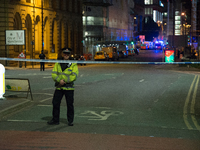 A police officer guards the cordoned off area, outside the Manchester Arena, after an explosion after the Ariana Grande concert which took p...
