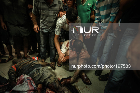 Bodies of the victim of an Israeli air strike at a market place to a stretcher near an ambulance in the Shejaiya neighbourhood near Gaza Cit...