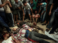 Bodies of the victim of an Israeli air strike at a market place to a stretcher near an ambulance in the Shejaiya neighbourhood near Gaza Cit...