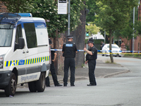 Police officers guard a cordoned street, a place where part of the investigation in to the Manchester Arena explosion is taking place, in Ma...