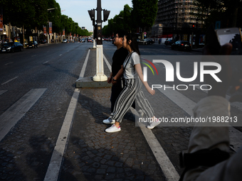 People are crossing champs elysees boulevard in Paris, France on May 28, 2017. Much of French people and tourists enjoyed hot and sunny weat...