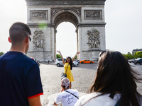 Tourists are taking selfies in front of the Triumphal Arch in Paris, France on May 28, 2017. Much of French people and tourists enjoyed hot...