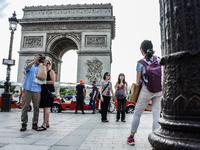 Tourists are taking selfies in front of the Triumphal arch in Paris, France on May 28, 2017. Much of French people and tourists enjoyed hot...