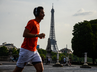 A man running in front of the Eiffel Tower in Paris, France on May 28, 2017. Much of French people and tourists enjoyed hot and sunny weathe...