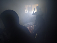 A Palestinian men tries to extinguish fire at a home after it was hit by an Israeli air strike in Rafah, the southern Gaza Strip, on July 31...