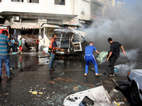 Palestinian firefighters try to put out the fire in a van after an Israeli air strike, in Gaza City, on 31 July 2014. (