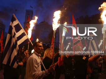 Supporters of the ultra nationalist party Golden Dawn hold torches, taking part to a rally in central Athens on Monday May 29, 2017  to comm...