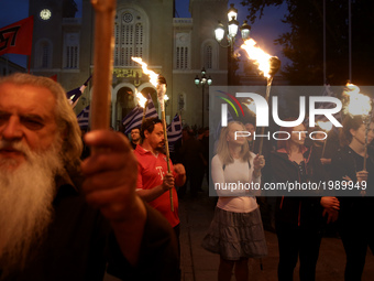 Supporters of the ultra nationalist party Golden Dawn hold torches, taking part to a rally in central Athens on Monday May 29, 2017  to comm...