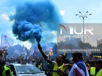 People holding smoke bombs march during a protest by a Spanish taxi drivers in Madrid on 30 th May, 2017. (