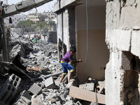 Palestinians inspect the destroyed house in Beit Hanoun , which witnesses said was heavily hit by Israeli shelling and air strikes during an...