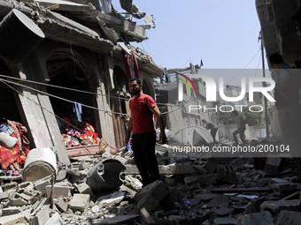 Palestinians inspect a destroyed house in the Bureij refugee camp in the central Gaza Strip on 01 August 2014. (