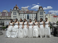 Chinese college graduates wearing wedding dress at St. Sophia Cathedral in Harbin as they take their group graduation photograph at Harbin o...